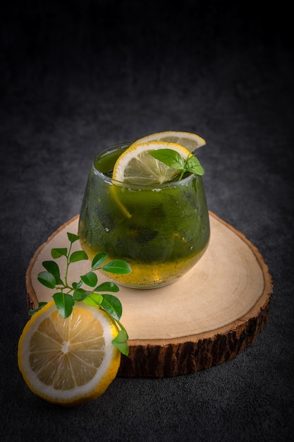 Cold lemon honey matcha decorated with lemon on a wooden cutting board