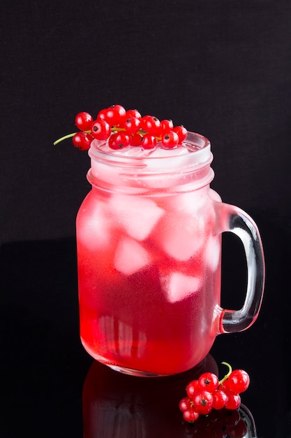 Cold lemonade with red currants in the glass  