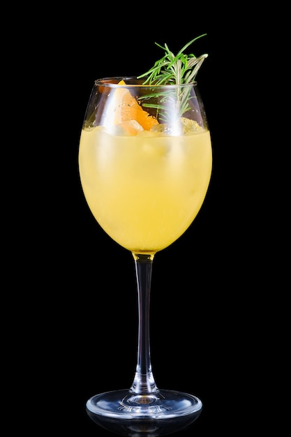 Cold orange lemonade with rosemary scent in a wine glass