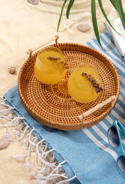 Cold pineapple cocktails on a wicker tray on beach with white sand Summer sea vacation and travel concept Exotic summer drinks