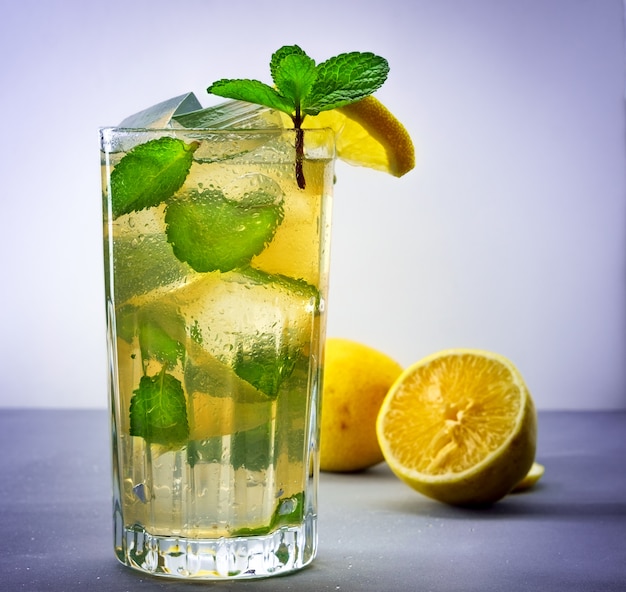 Cold refreshing summer lemonade in a glass on a grey background