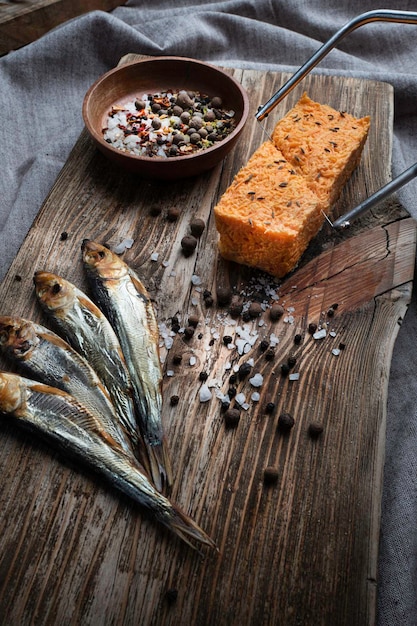 Cold smoked fish on an old wooden board with spices