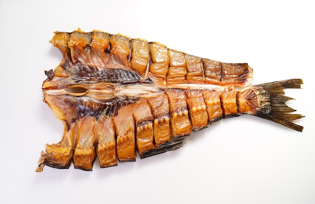 Cold-smoked silver carp fish on a white surface.