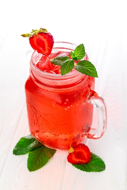 Cold strawberry lemonade in mason jar isolated