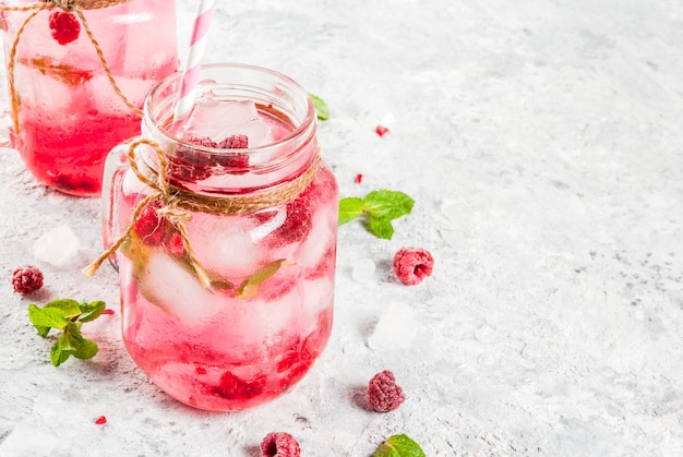 Cold summer drink, Raspberry Sangria, Lemonade or Mojito with fresh Raspberry and syrup