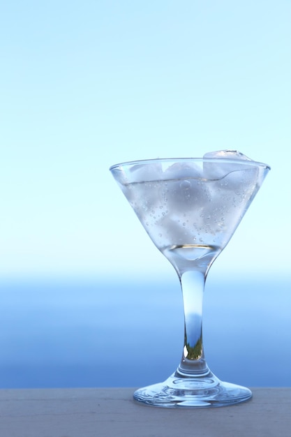 Cold transparent cocktail in glass with ice cubes