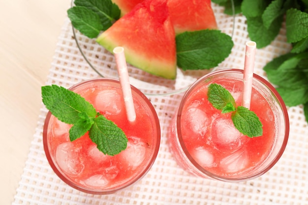 Cold watermelon desserts and drinks in glasses on wooden table background