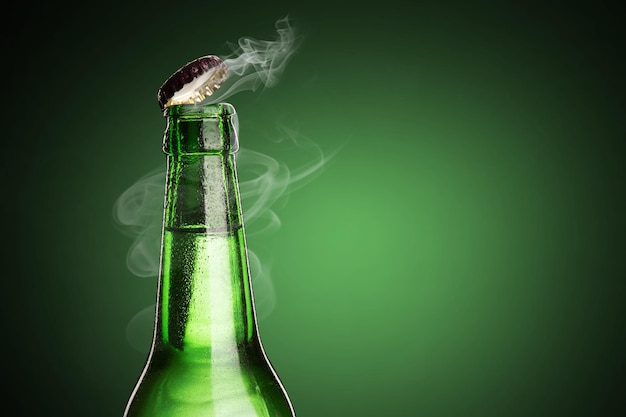 Cold wet bottle of chilled drink with drops Opening of beer cap with the gas output