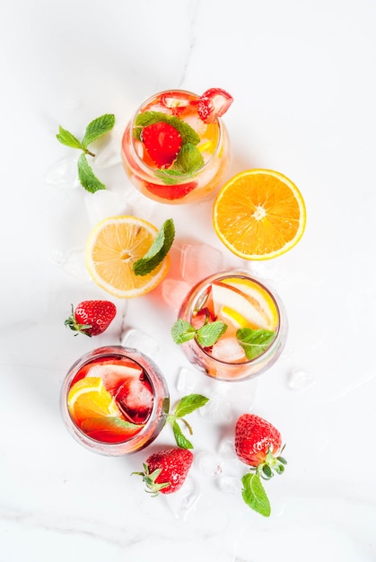 Cold white pink and red sangria cocktails with fresh fruits berries and mint. above