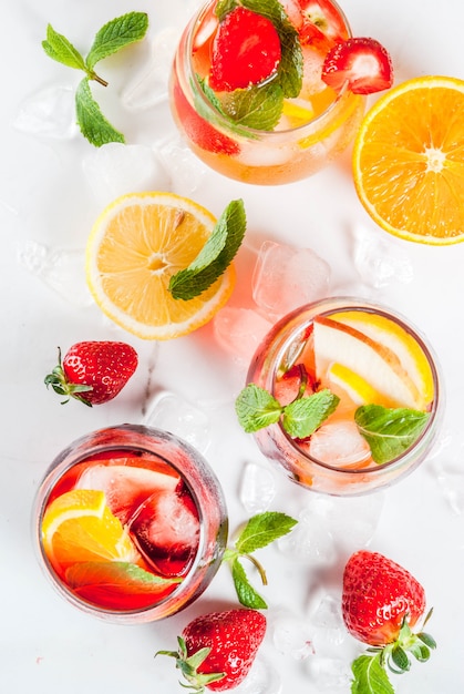 Cold white, pink and red sangria cocktails with fresh fruits, berries and mint