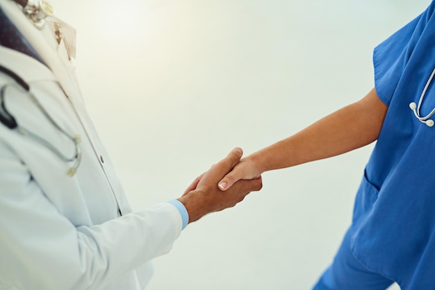 Collaboration goes a long way in medicine High angle shot of two unidentifiable healthcare practitioners shaking hands in the hospital foyer