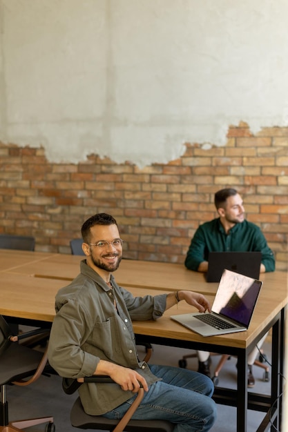 Photo collaboration in motion professionals working together in a modern brickwalled office