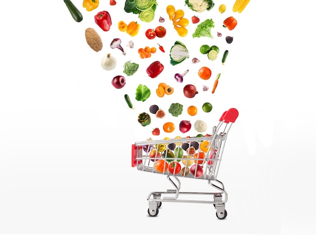 Collage of shopping cart with vegetables and fruits isolated