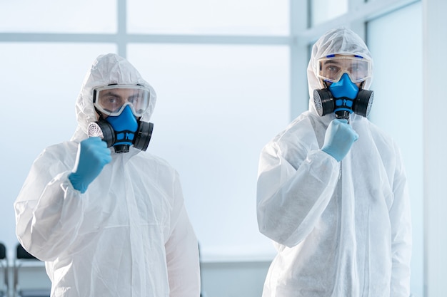 Colleagues in biohazard suits standing in the lab. concept of health protection.