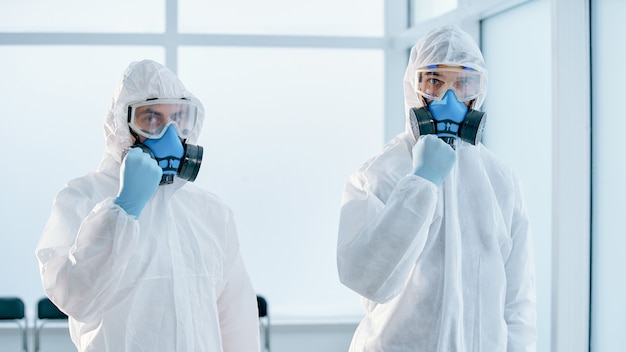 Colleagues in biohazard suits standing in the lab