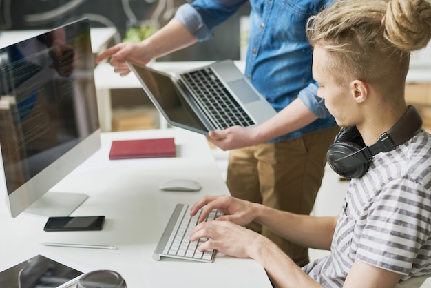 Colleagues coding information in office