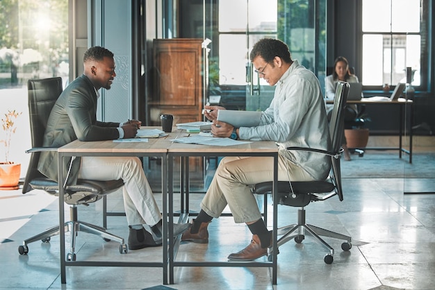 Colleagues coworkers or male employees collaborating and planning a business growth strategy together in an office Happy corporate professionals working on a project proposal at a modern workplace