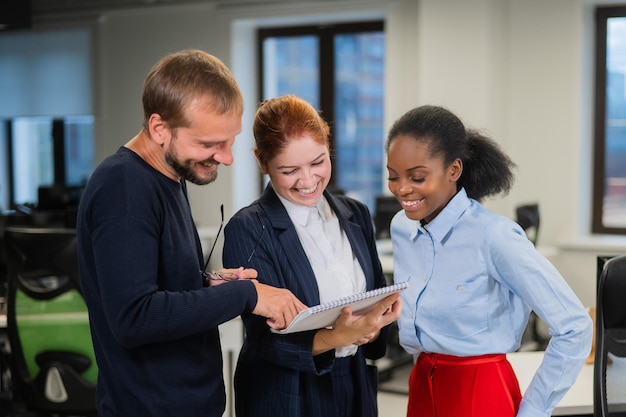 Colleagues discuss work african young woman caucasian man and red-haired caucasian woman