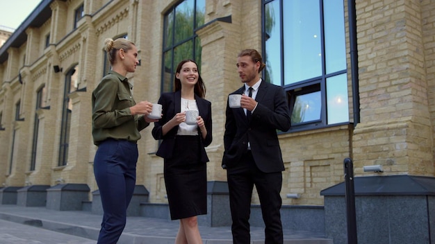 Colleagues having break work outdoors Business people drinking coffee outside