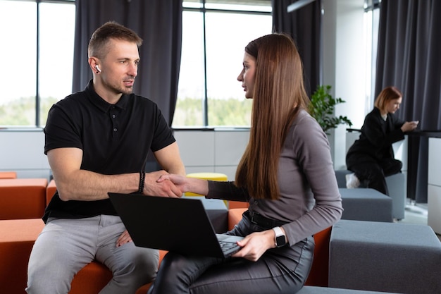 Colleagues shake hands during a meeting in the office