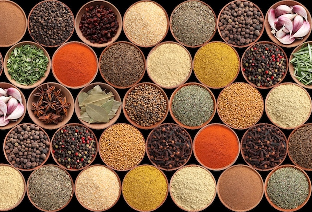 Collection of different aromatic spices and herbs on black background flat lay