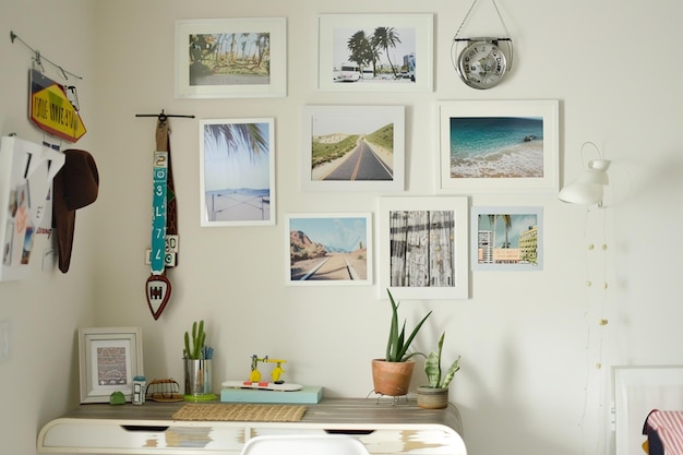 Photo a collection of framed pictures hang on a wall above a desk