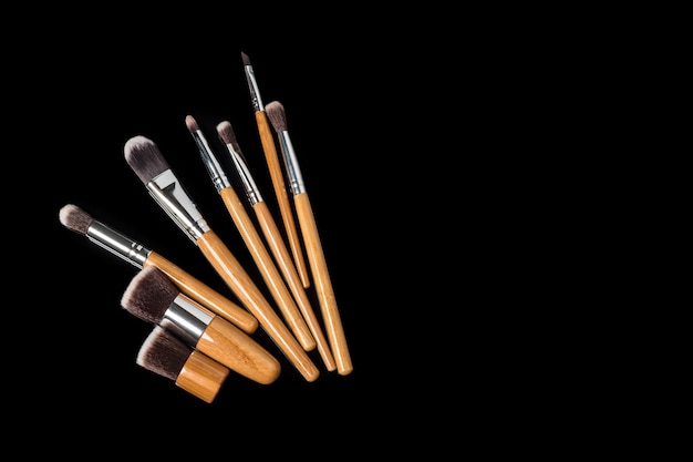 Collection of professional makeup brushes on black surface