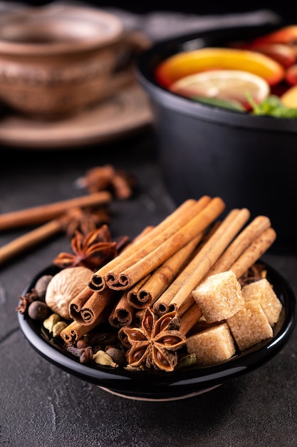 Collection of spices for mulled wine and pastry on black background