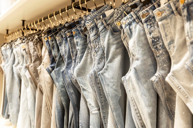 Collection of women's jeans on hangers in a boutique Fashion style and beauty