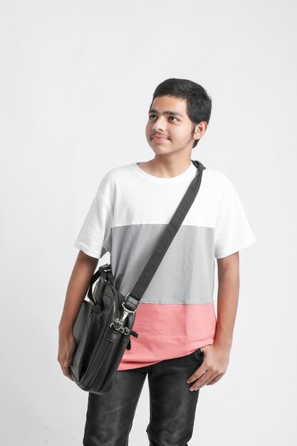 College Boy holding schoolbag on white wall