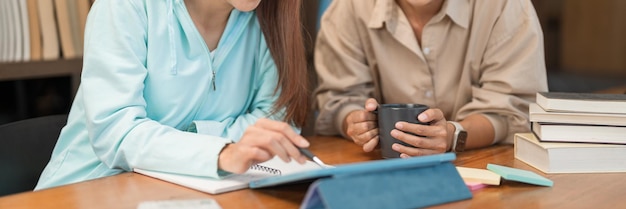 College education concept Teenage girl pointing homework on tablet to asking question with tutor