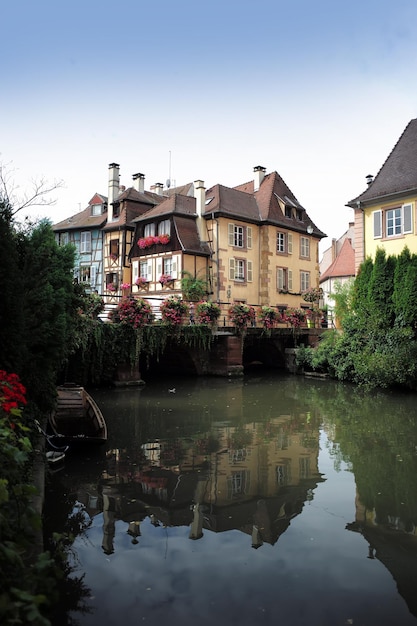 COLMAR FRANCE September 18 2015 Picturesque view on canal with traditional french halftimbered houses and bridge with flowers in Colmar vertical photo