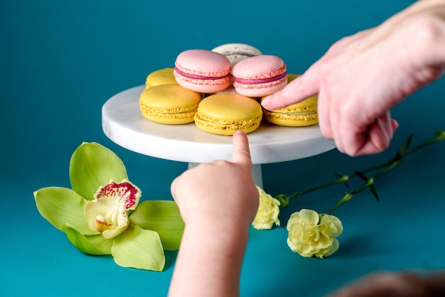 Color macarons macaroons on white marbel cake stand.