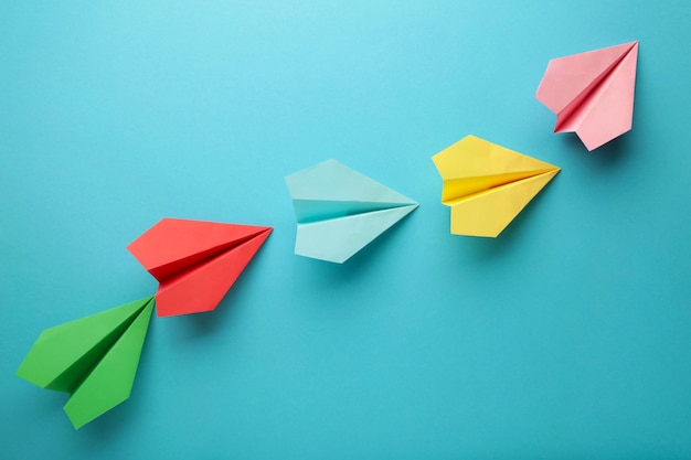 Color paper plane on blue background, Business competition concept. Top view