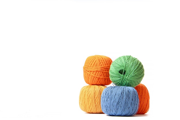 Colored balls of crochet thread on white