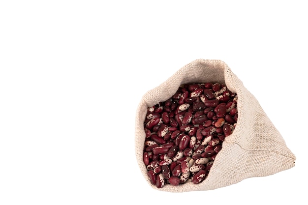 Colored beans red and white bean seeds in a linen bag White isolated background