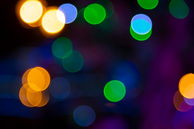 Colored blurred bokeh. abstract background of included festive garlands. colorful blur light bulbs