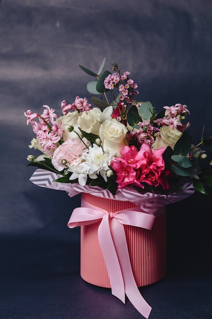 Colored bouquet in basket on dark background