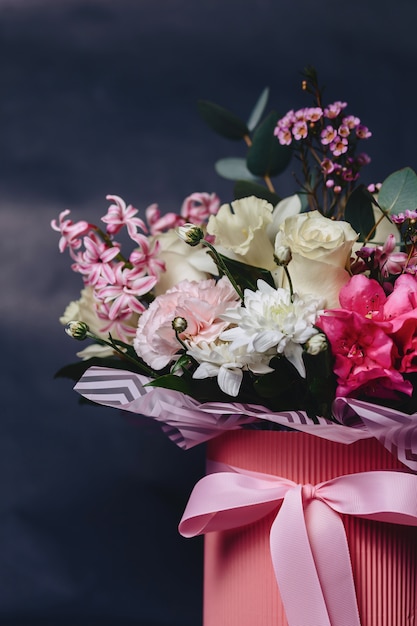 Colored bouquet in basket on dark background