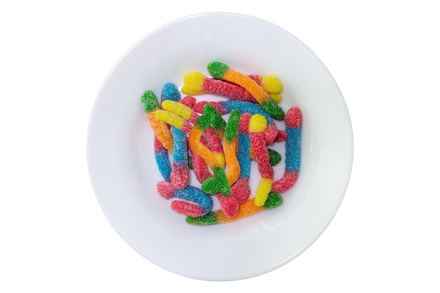 Colored candies on white plate Top view