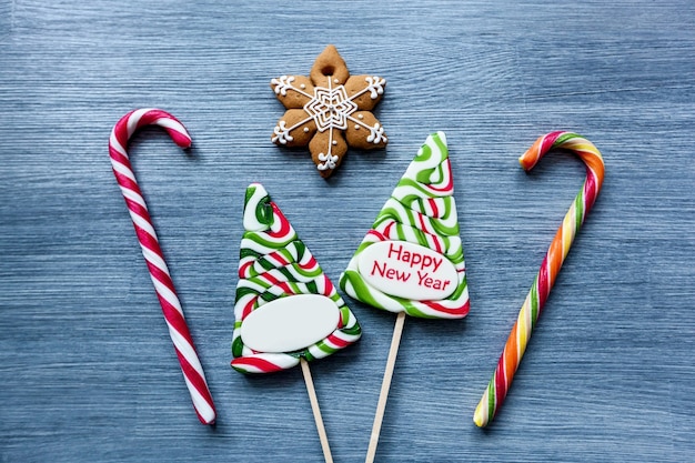 Colored candy lollipops New Years sweets on a blue background Christmas tree snowman