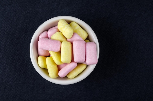 Colored chewing gum in a white bowl