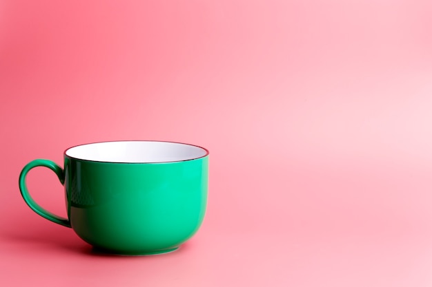 Colored cup on an empty colored background, minimal concept background. Home cookware and morning idea.