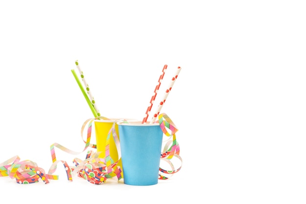 Colored drinking straws in yellow and light blue paper glasses on a white background