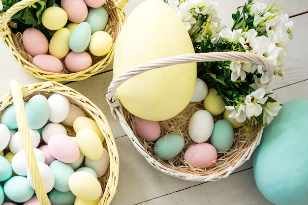 Colored easter eggs and flowers in wicker baskets. copy space - Easter concept