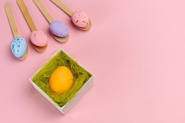 Colored Easter eggs on wooden spoons with a gift box