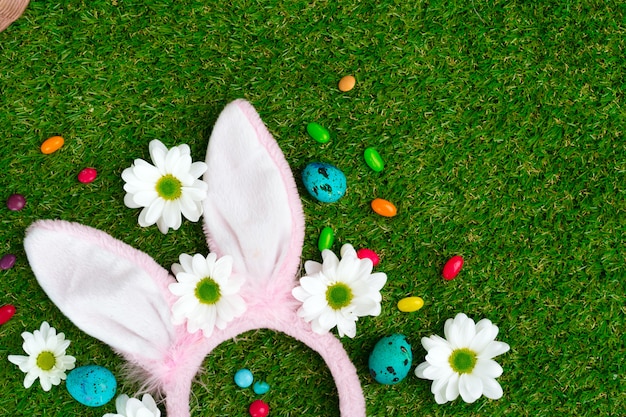 Colored eggs and vibrant candies on grass. Easter composition