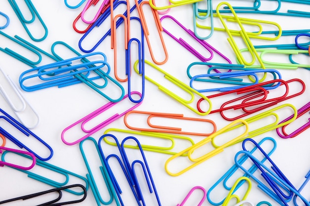 Colored paper clips on white background, Close-up.