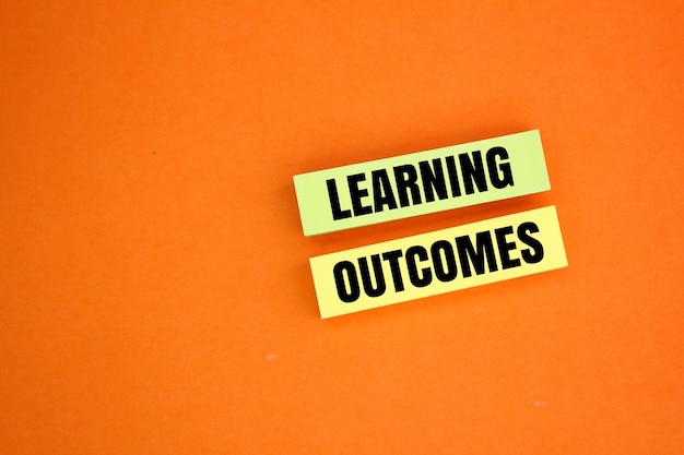 colored paper with the words Learning outcomes learning concept concept of income from learning