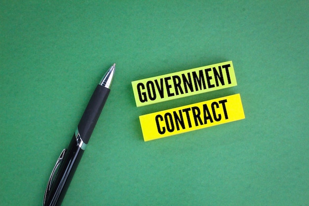 colored pen and paper with the word government contract the concept of an agreement